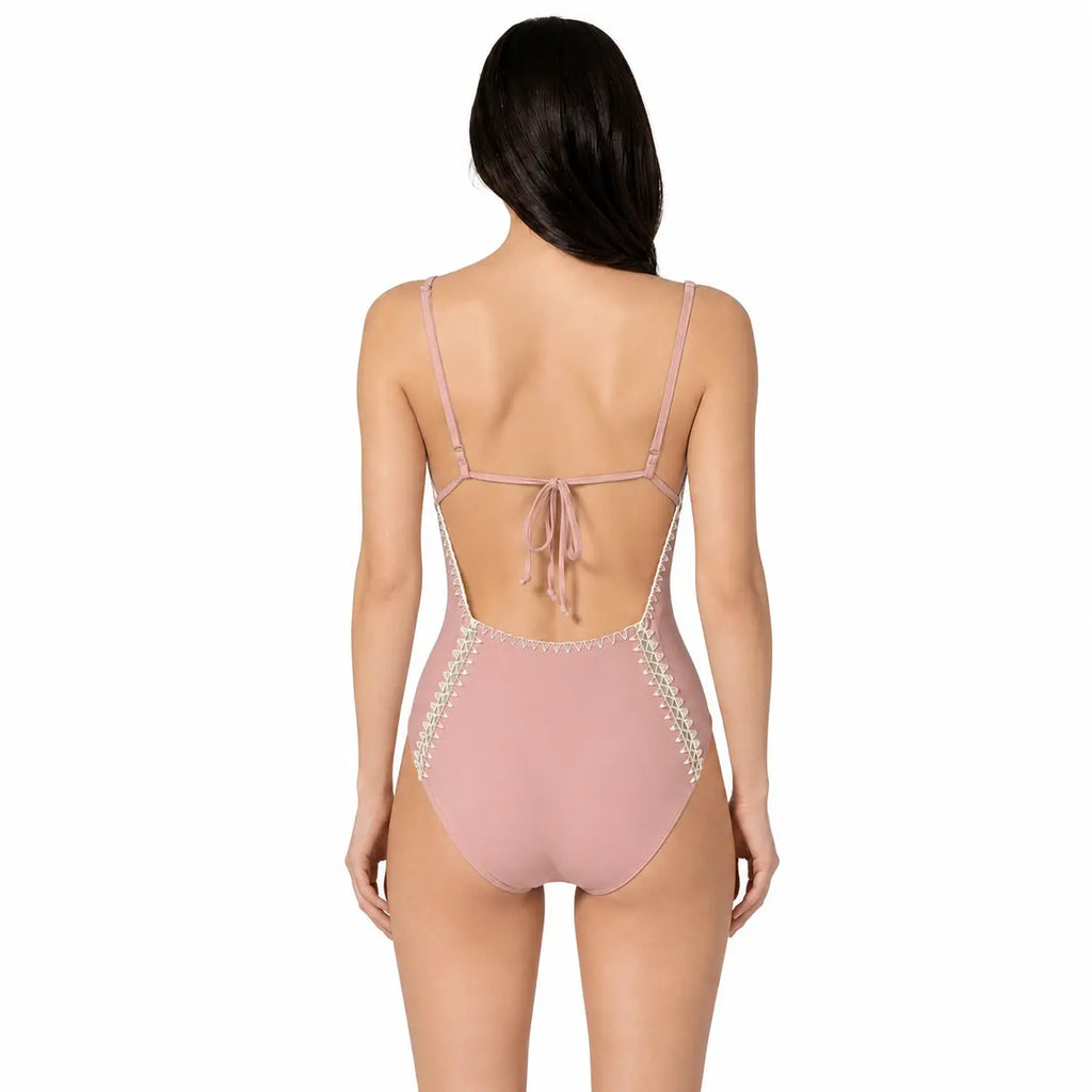 Pink swimsuit with lace details on a white background