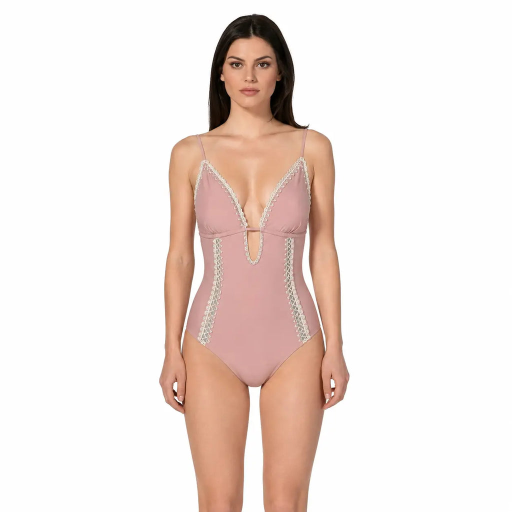 Woman wearing a pink swimsuit with lace details on a white background