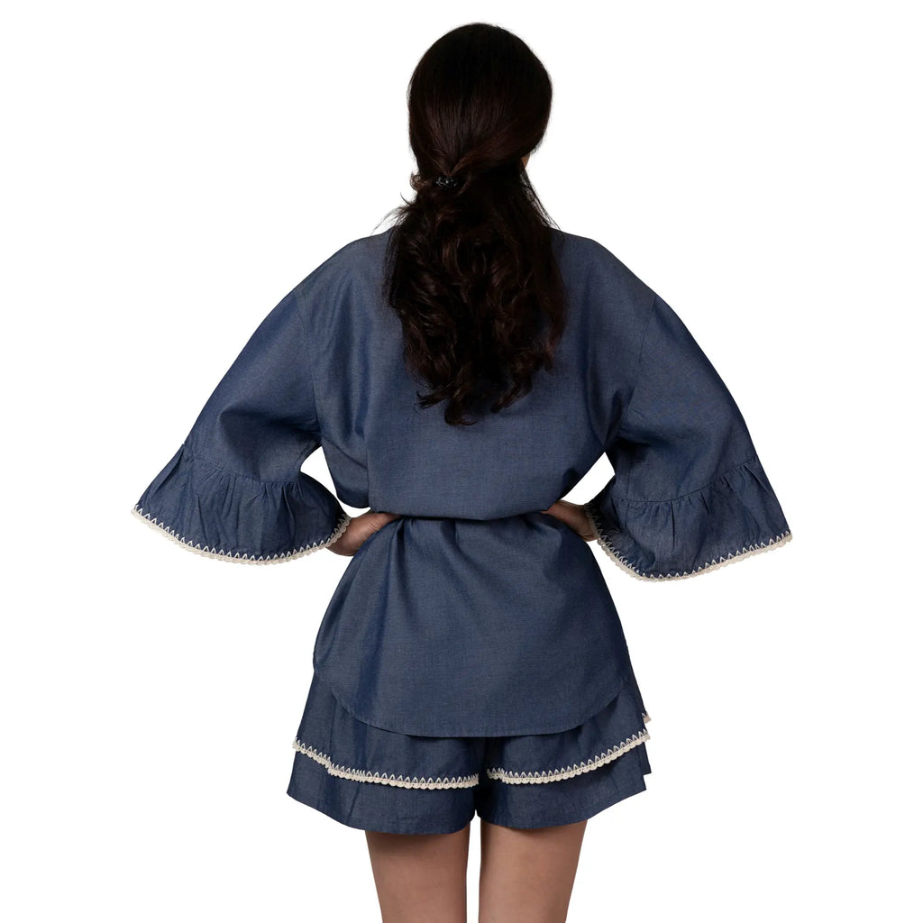 AMELIE DENIM Boutique Blouse by BILEYA COUTURE crafted from 100% cotton denim, featuring a classic collar, flared 3/4 sleeves, handcrafted details, an adjustable waist tie, and a feminine silhouette for elegant casual and resort-inspired styling.

