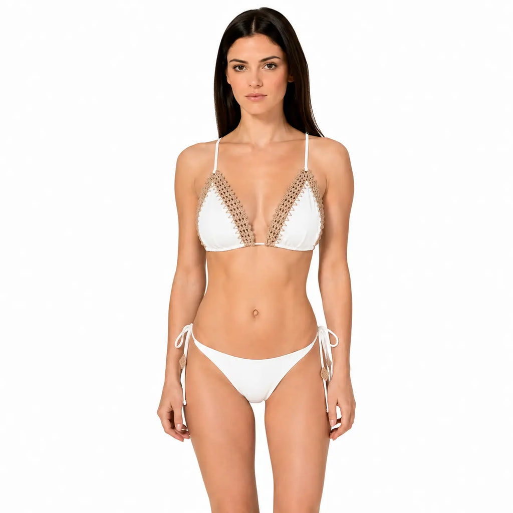 Woman wearing a white bikini with gold embellishments on a white background