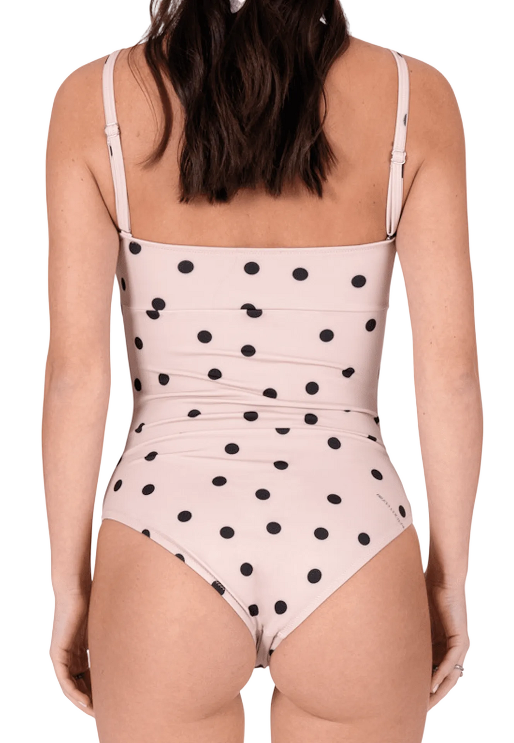 One-piece swimsuit with black polka dots on a light pink background