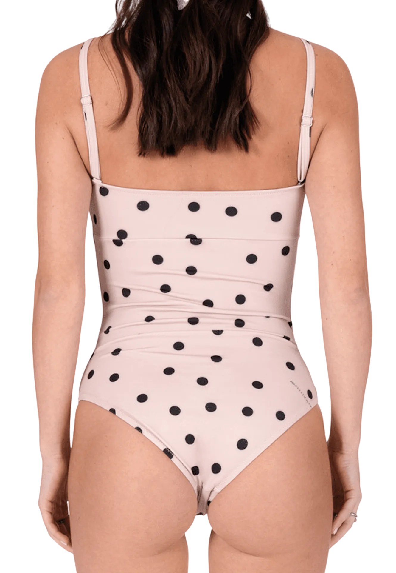 One-piece swimsuit with black polka dots on a light pink background