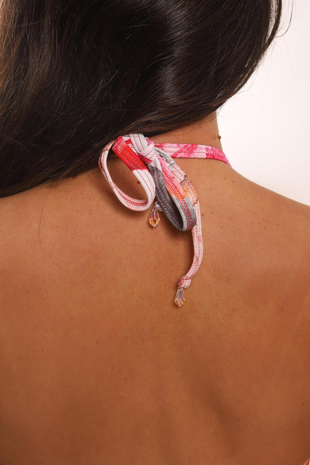 Necklace with colorful braided design on a person's neck
