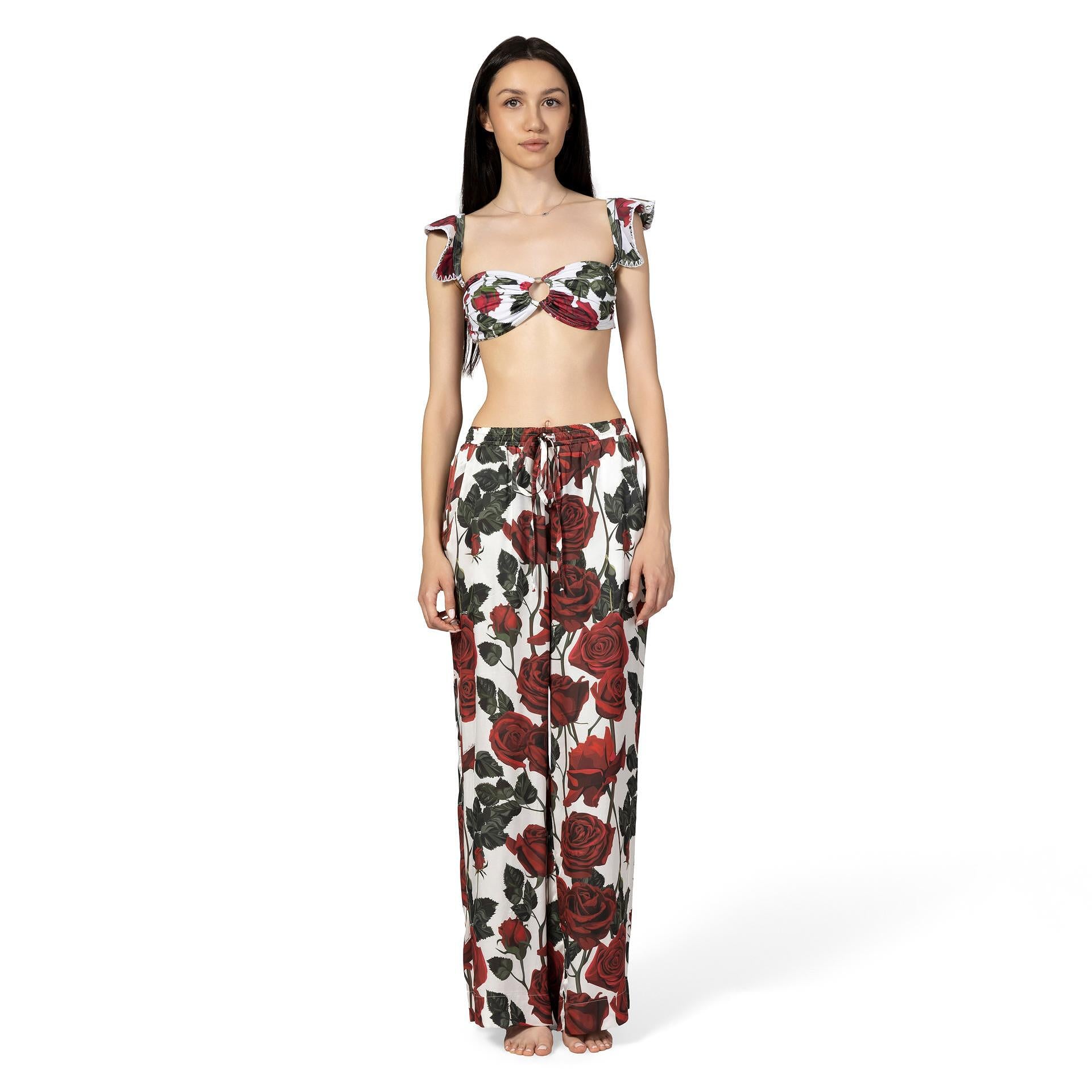 Woman wearing a floral top and pants set on a white background