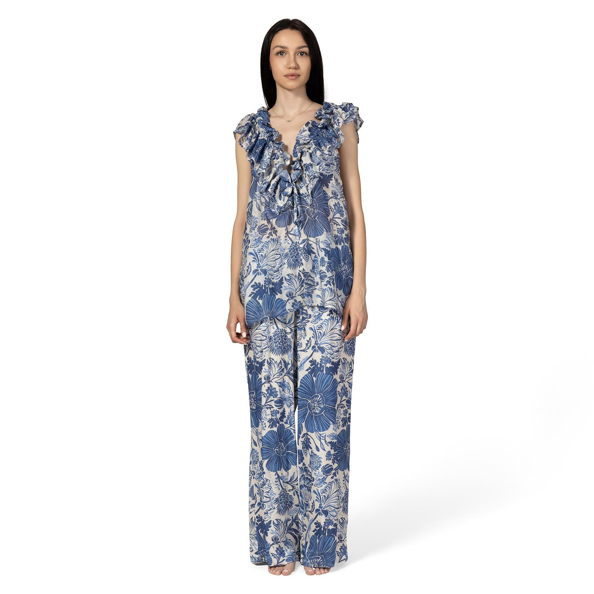 Woman wearing a blue floral jumpsuit on a white background